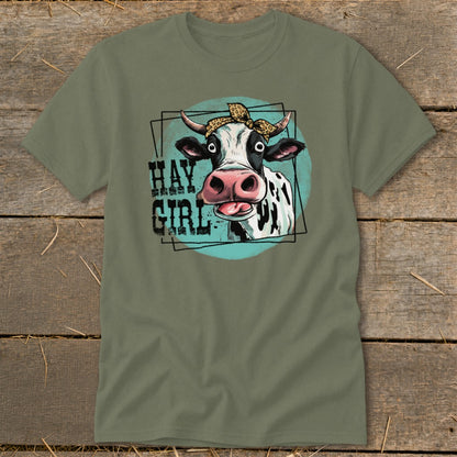 Cow with bandana and text "HAY GIRL" on a green t-shirt.