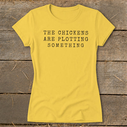 Yellow t-shirt with black text reading "The Chickens Are Plotting Something".