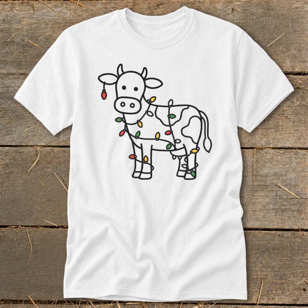 White t-shirt with a black outline drawing of a cow wrapped in colorful Christmas lights.