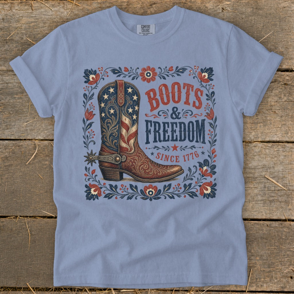 Light blue t-shirt with a cowboy boot graphic and "Boots & Freedom Since 1776" text.