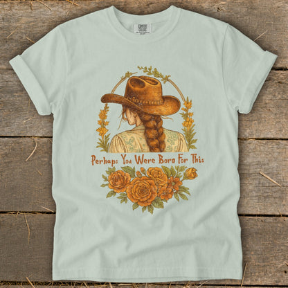 T-shirt graphic: woman in cowboy hat, braided hair, flowers, and text "Perhaps You Were Born For This".