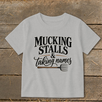 Light grey t-shirt with "MUCKING STALLS & taking names" and a pitchfork.