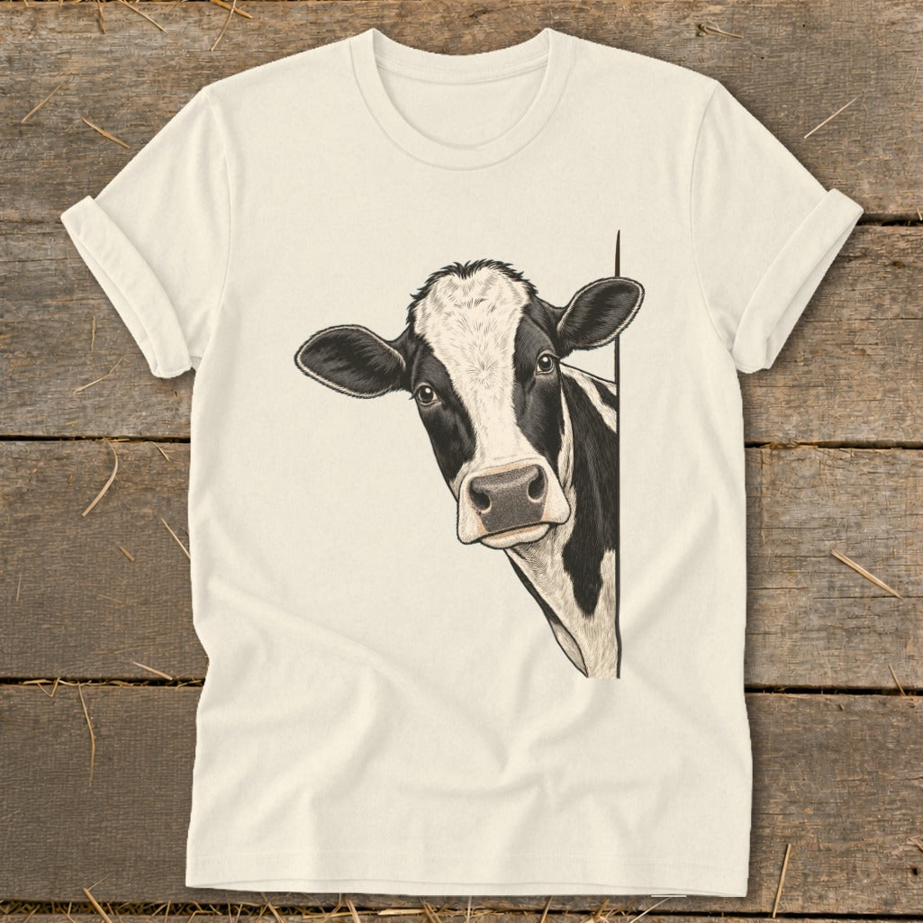 Black and white cow peeking from behind a white t-shirt.