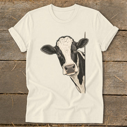 Black and white cow peeking from behind a white t-shirt.