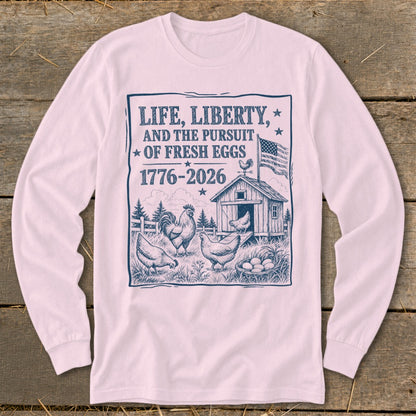 T-shirt graphic with chickens, coop, and text "Life, Liberty, and the Pursuit of Fresh Eggs 1776-2026".