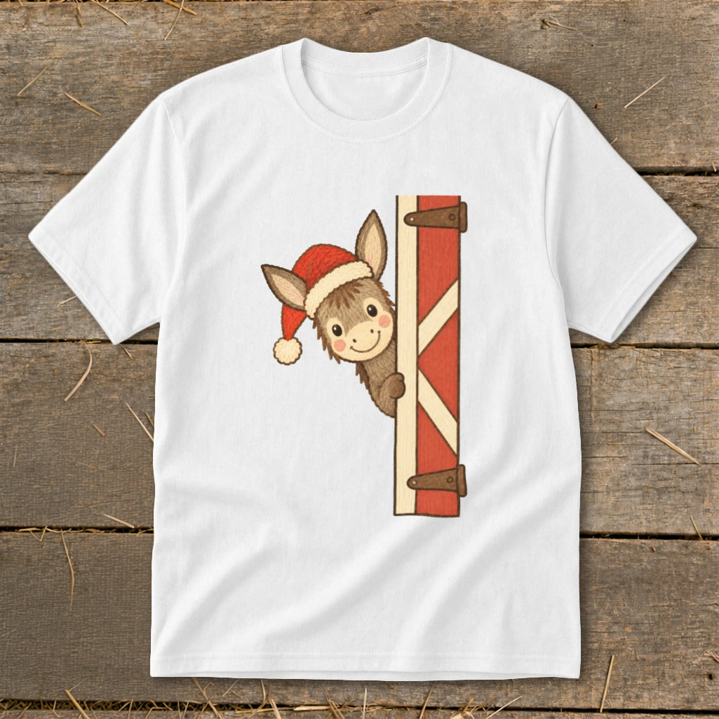 Christmas donkey wearing a Santa hat peeking around a barn door.