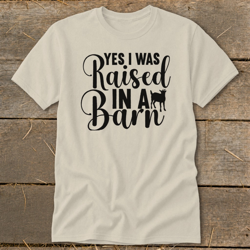 Cream t-shirt with black text "Yes I Was Raised In A Barn" and a goat silhouette.