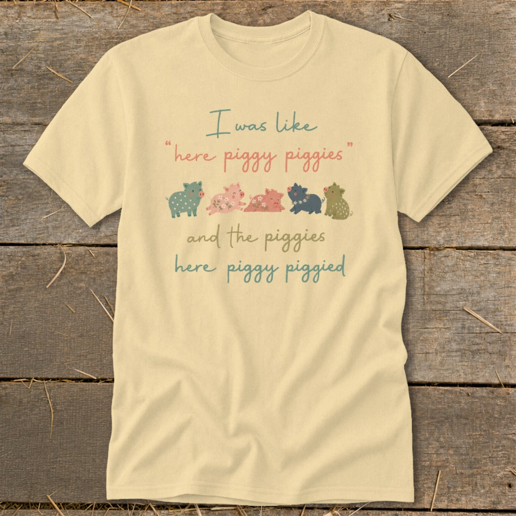 Cream t-shirt with "I was like 'here piggy piggies' and the piggies here piggy piggied" text and pig illustrations.