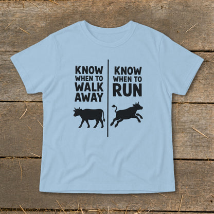 Light blue t-shirt with black text and cow graphics: "Know When to Walk Away" and "Know When to Run."