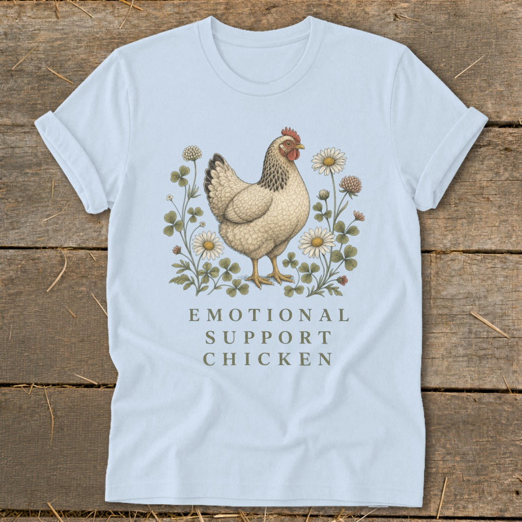 Light blue t-shirt with a hen illustration surrounded by flowers and text reading "EMOTIONAL SUPPORT CHICKEN".