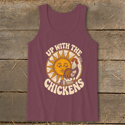 A maroon tank top with a vintage graphic of a rooster crowing before a sun, featuring the text Up with the Chickens.
