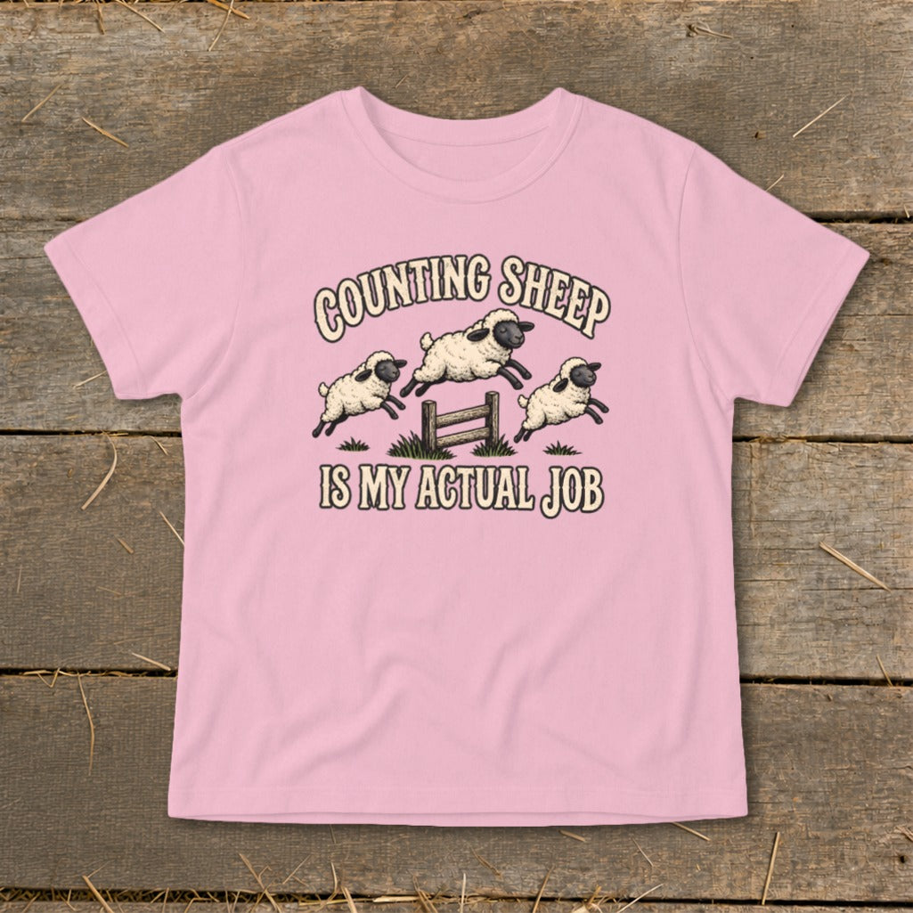 Pink t-shirt with "COUNTING SHEEP IS MY ACTUAL JOB" text and jumping sheep graphic.
