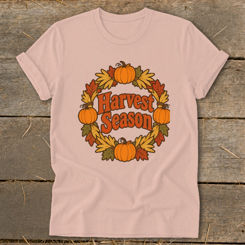 Pink t-shirt with "Harvest Season" text within a pumpkin and leaf wreath.