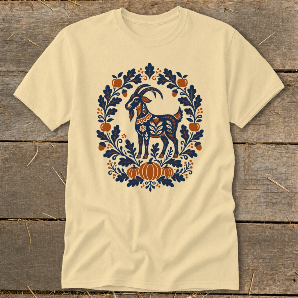 Beige t-shirt featuring a folk art illustration of a goat surrounded by leaves, acorns, and pumpkins.