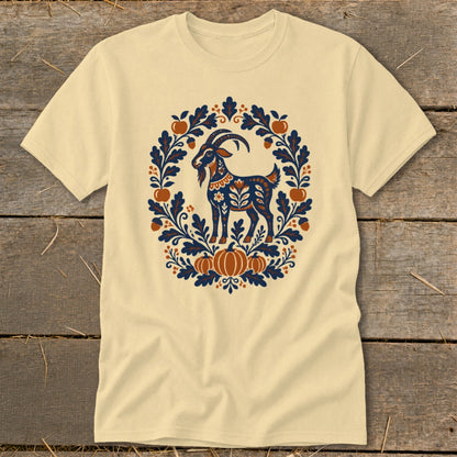 Beige t-shirt featuring a folk art illustration of a goat surrounded by leaves, acorns, and pumpkins.