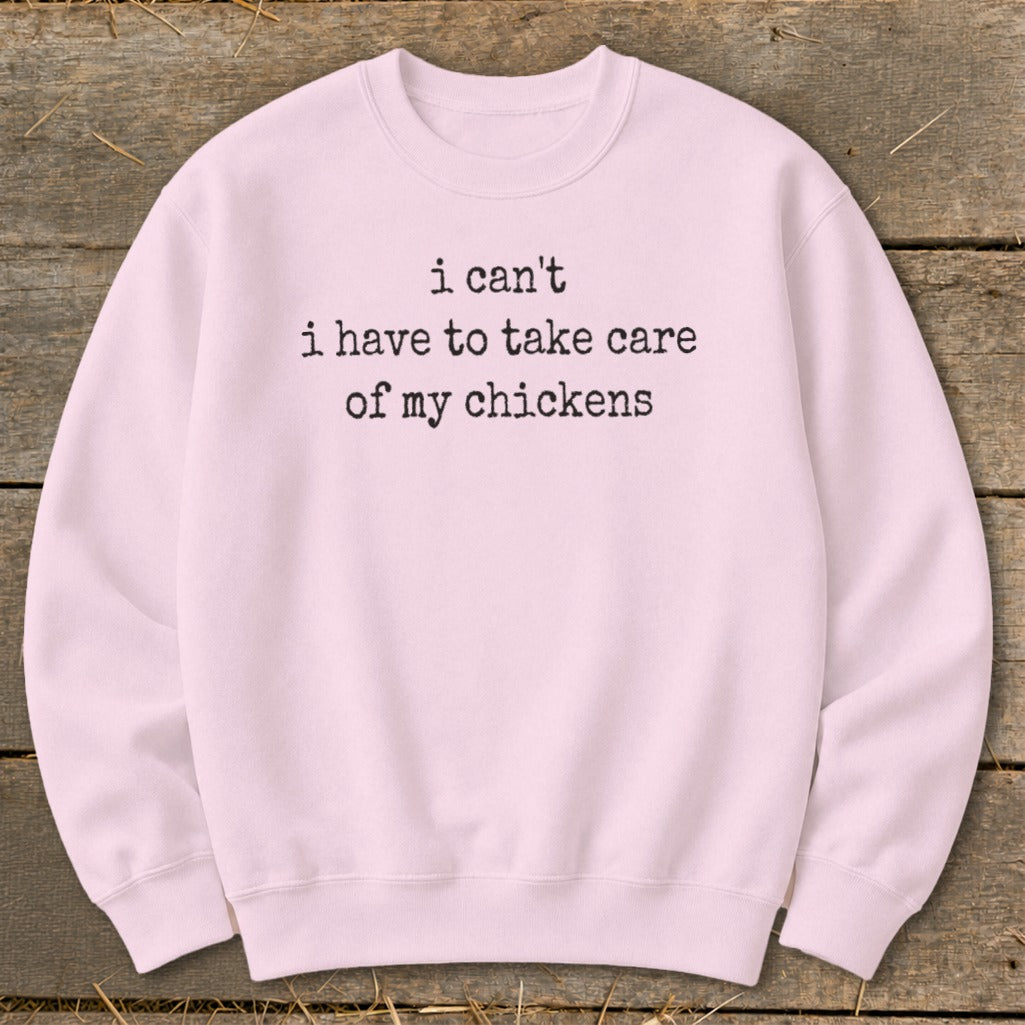 Pink crewneck sweatshirt with black text reading "i can't i have to take care of my chickens".
