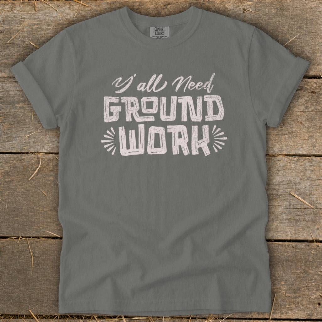 Gray t-shirt with white text reading "Y'all Need GROUND WORK".
