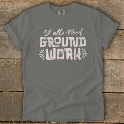 Gray t-shirt with white text reading "Y'all Need GROUND WORK".