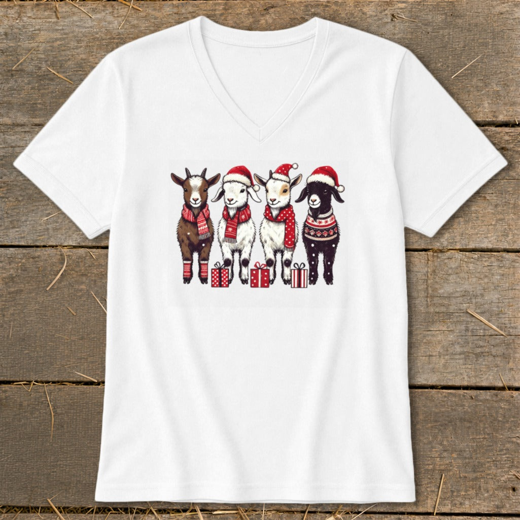 Four goats in Santa hats and scarves stand with presents.