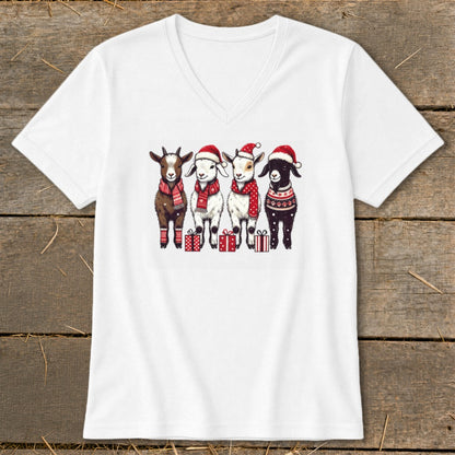 Four goats in Santa hats and scarves stand with presents.
