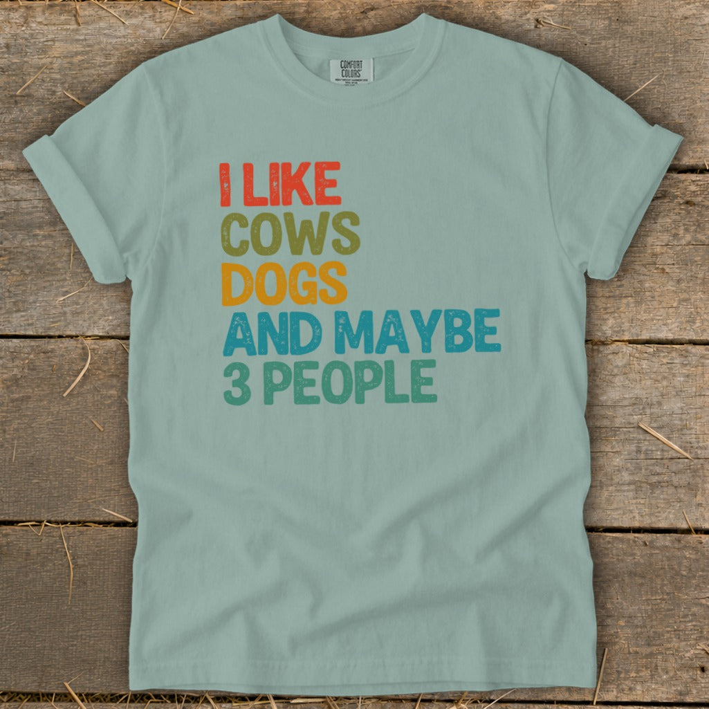 I like cows, dogs, and maybe 3 people text on a light blue t-shirt.