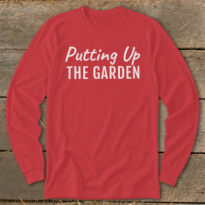Red long-sleeve t-shirt with "Putting Up THE GARDEN" printed in white.