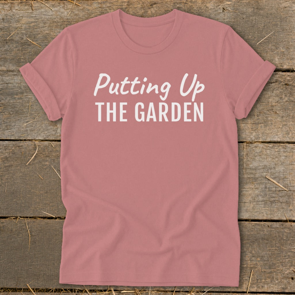 Dusty rose t-shirt with white text reading "Putting Up THE GARDEN".