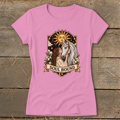 Pink t-shirt with a woman embracing a white horse under a sun and stars with "SOUL BOUND" text.