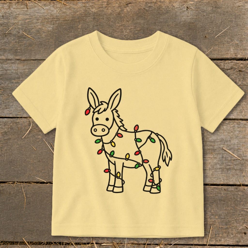 Light yellow t-shirt with a cartoon donkey wrapped in colorful Christmas lights.