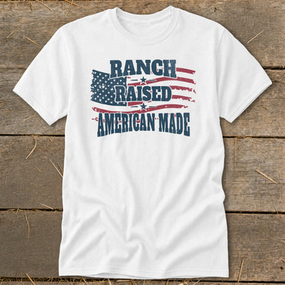White t-shirt with "Ranch Raised American Made" text overlaying distressed American flag graphic.
