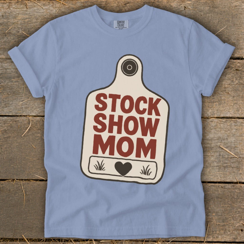 Light blue t-shirt with "Stock Show Mom" text on a tag graphic.