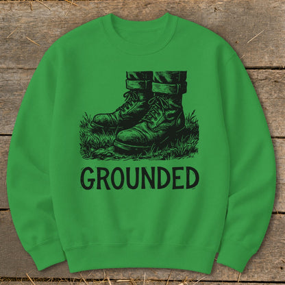 Green sweatshirt with black graphic of boots in grass and text "GROUNDED".