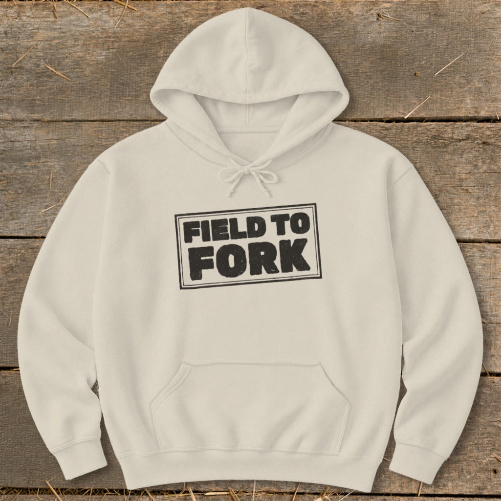 A cream-colored hoodie featuring the black text Field to Fork inside a bordered box.
