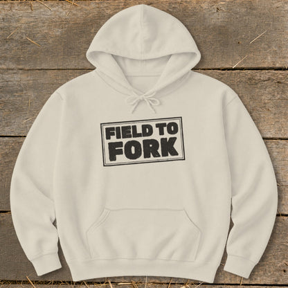 A cream-colored hoodie featuring the black text Field to Fork inside a bordered box.
