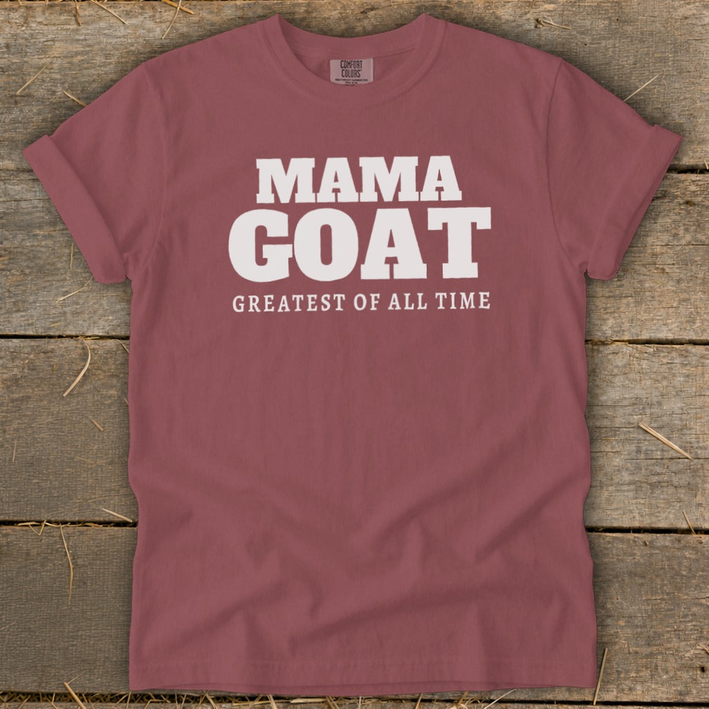 Maroon t-shirt with white text that reads "MAMA GOAT GREATEST OF ALL TIME".