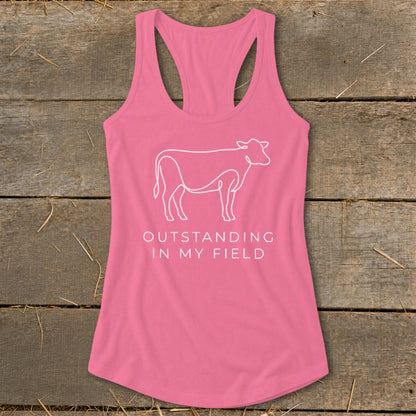 Pink tank top with white line art cow and text "OUTSTANDING IN MY FIELD".