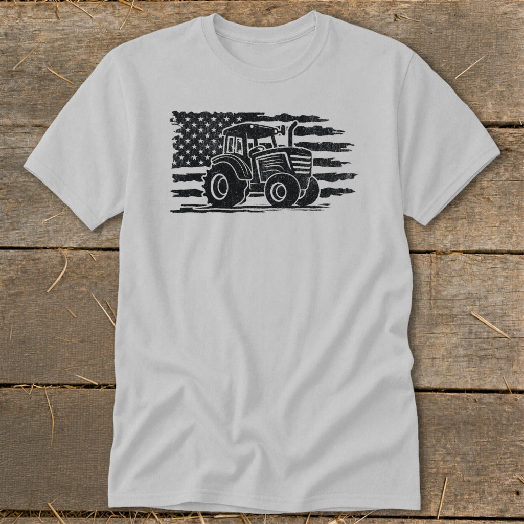 Tractor graphic on distressed American flag on light gray t-shirt.
