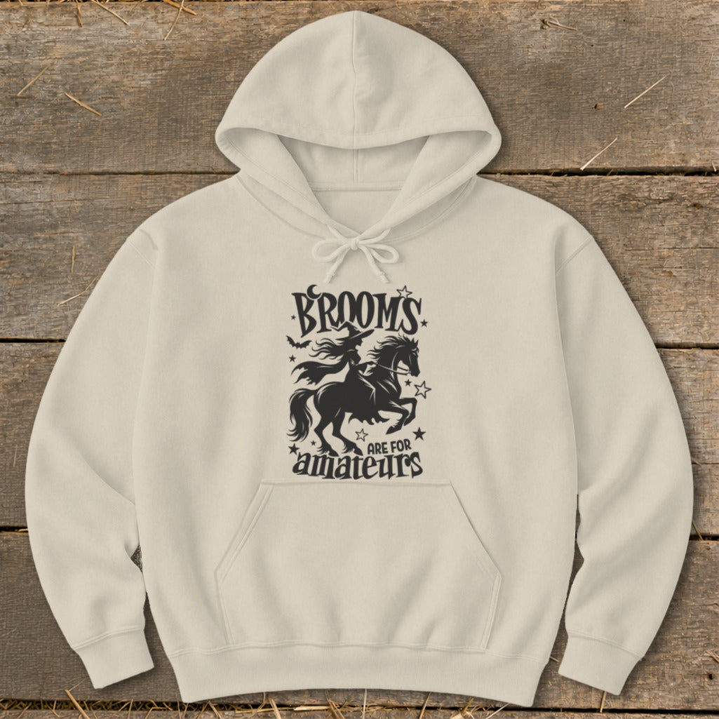 Cream hoodie with witch on horse graphic and text "Brooms are for amateurs".
