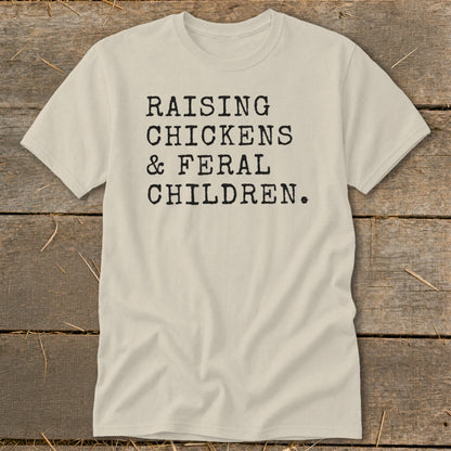 Light tan t-shirt with black text reading "RAISING CHICKENS & FERAL CHILDREN."