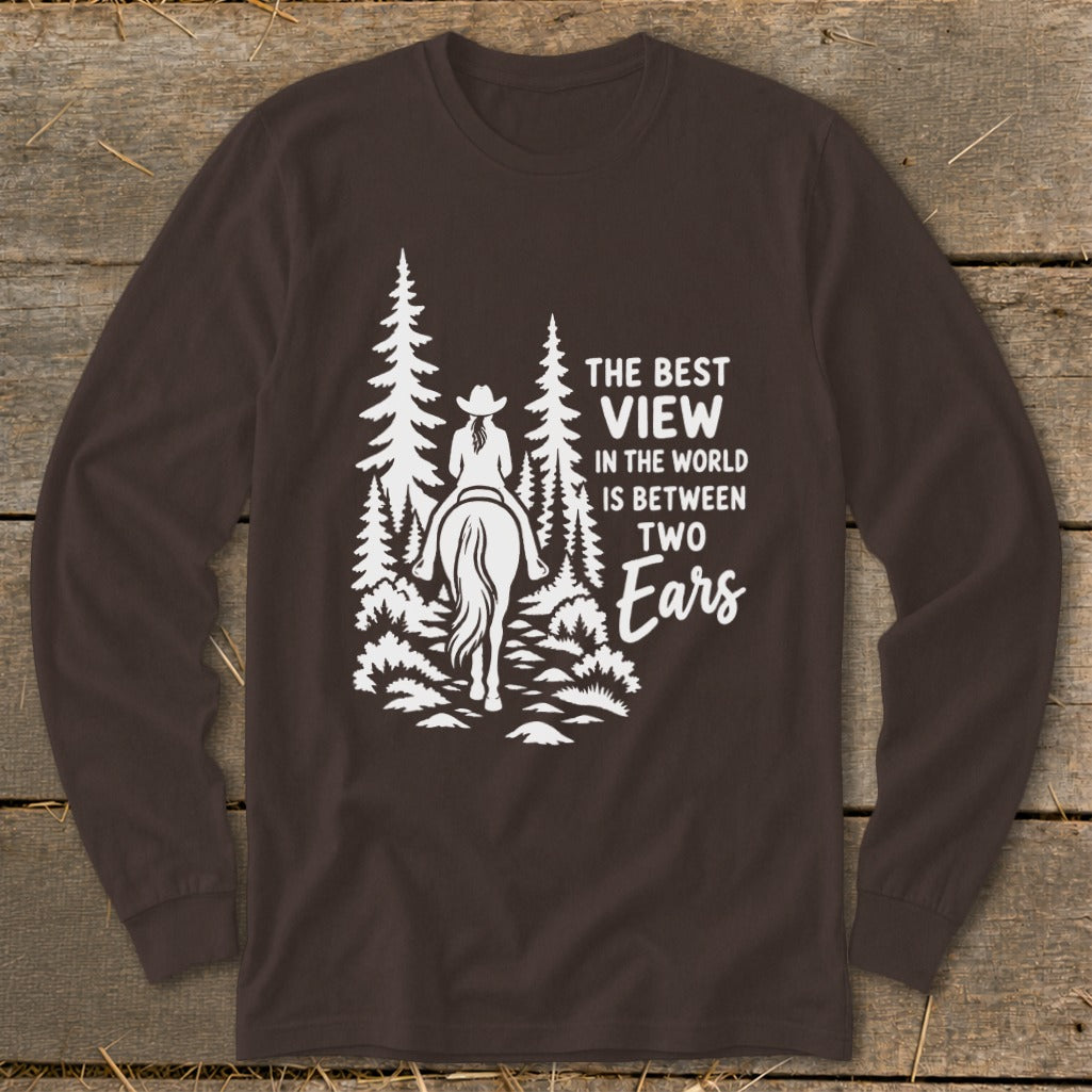 Brown long-sleeve shirt with a white graphic of a horseback rider in the woods and text reading The Best View In The World Is Between Two Ears.