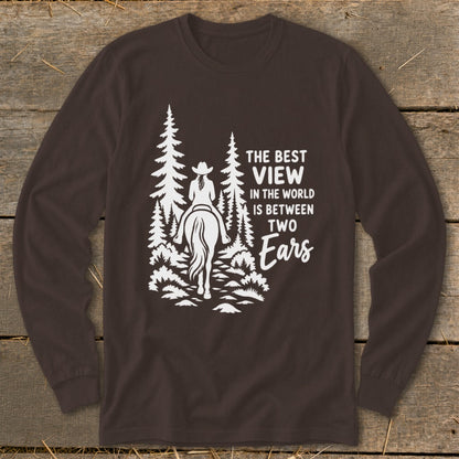 Brown long-sleeve shirt with a white graphic of a horseback rider in the woods and text reading The Best View In The World Is Between Two Ears.
