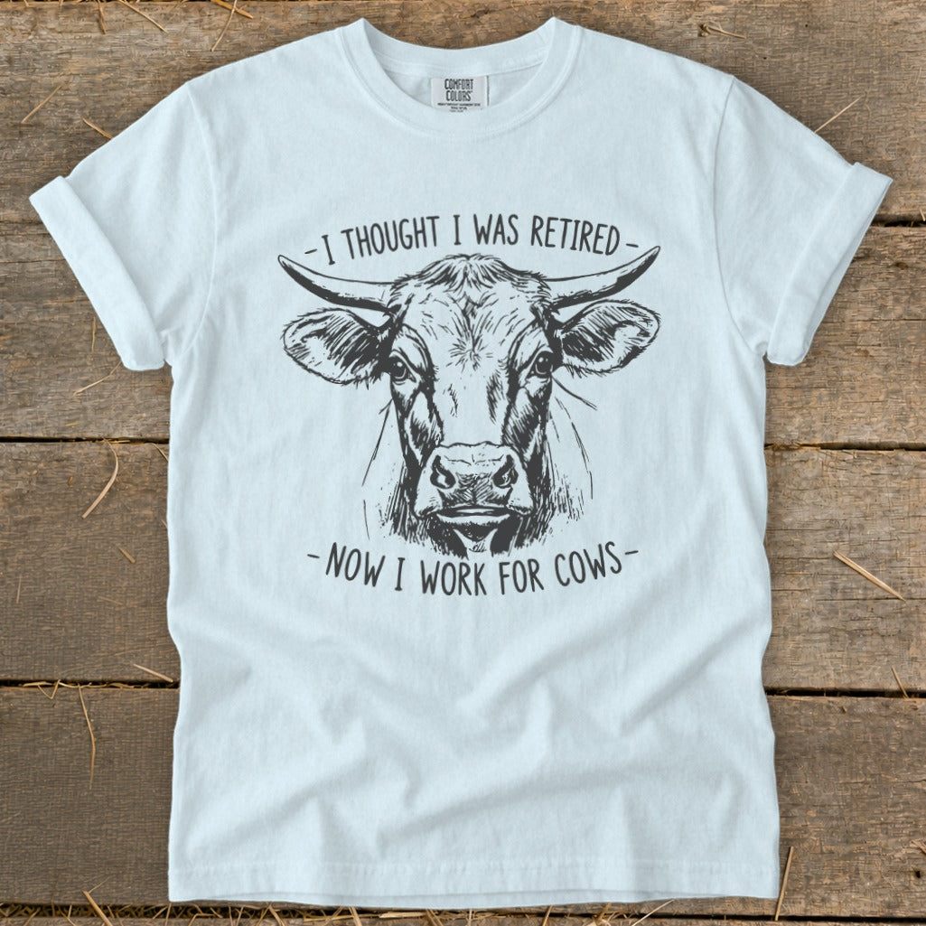 White t-shirt with a bull's head graphic and text: "Now I work for cows".