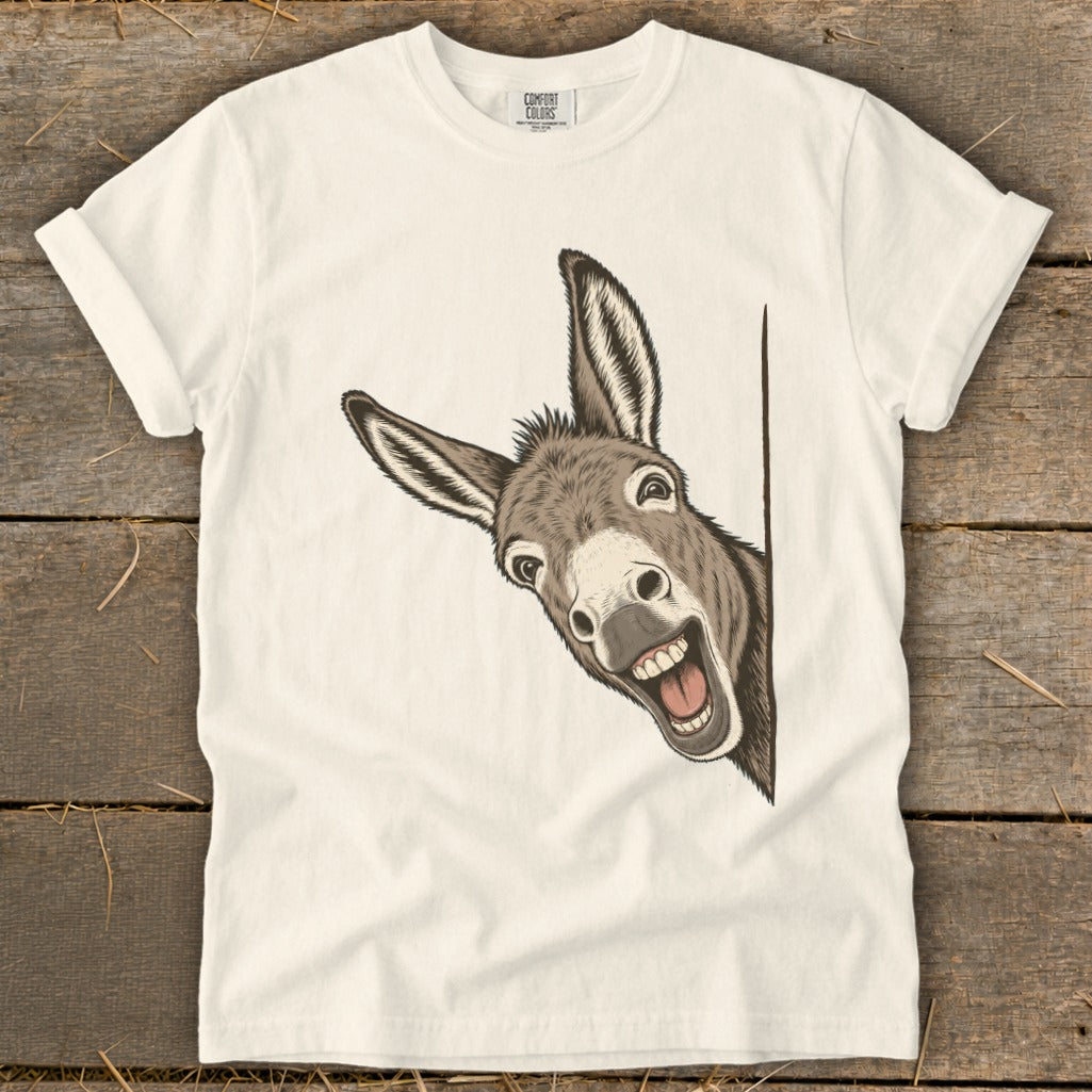 White t-shirt with a drawing of a happy donkey peeking around a corner.