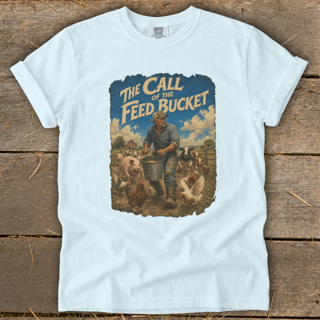 T-shirt graphic: Farmer feeding livestock with "The Call of the Feed Bucket" title.