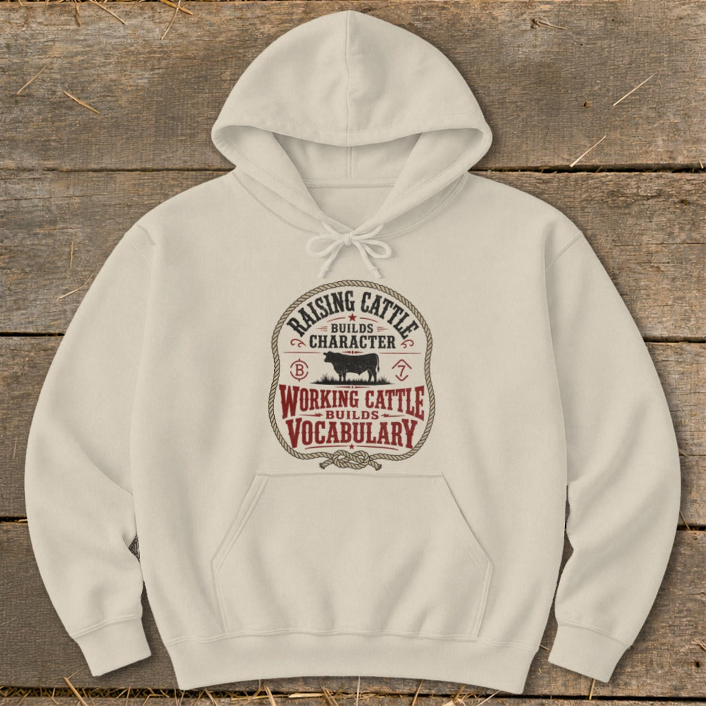 Cream hoodie with graphic "Raising Cattle Builds Character, Working Cattle Builds Vocabulary".