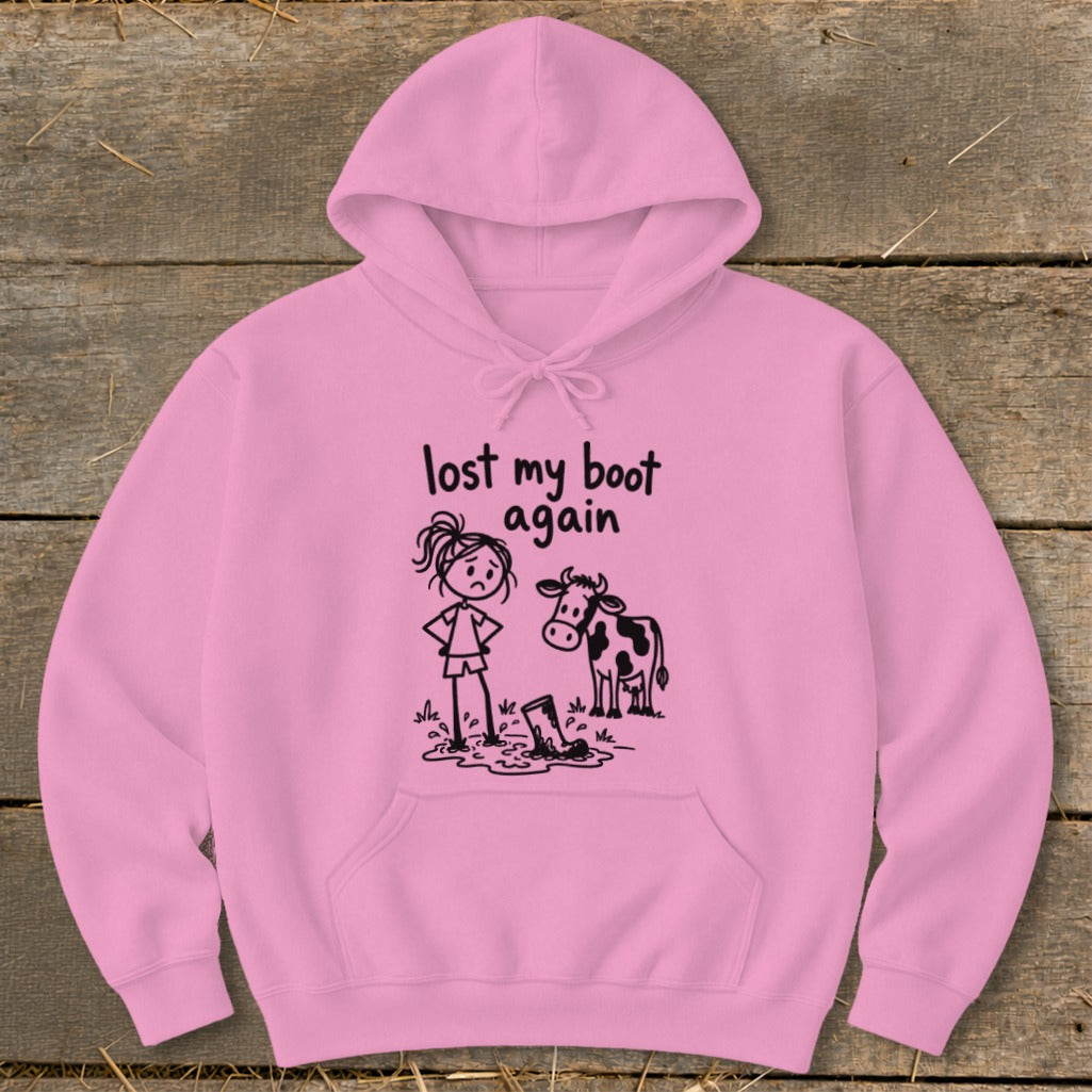 A pink hoodie featuring a graphic of a sad girl, a cow, and the text lost my boot again.