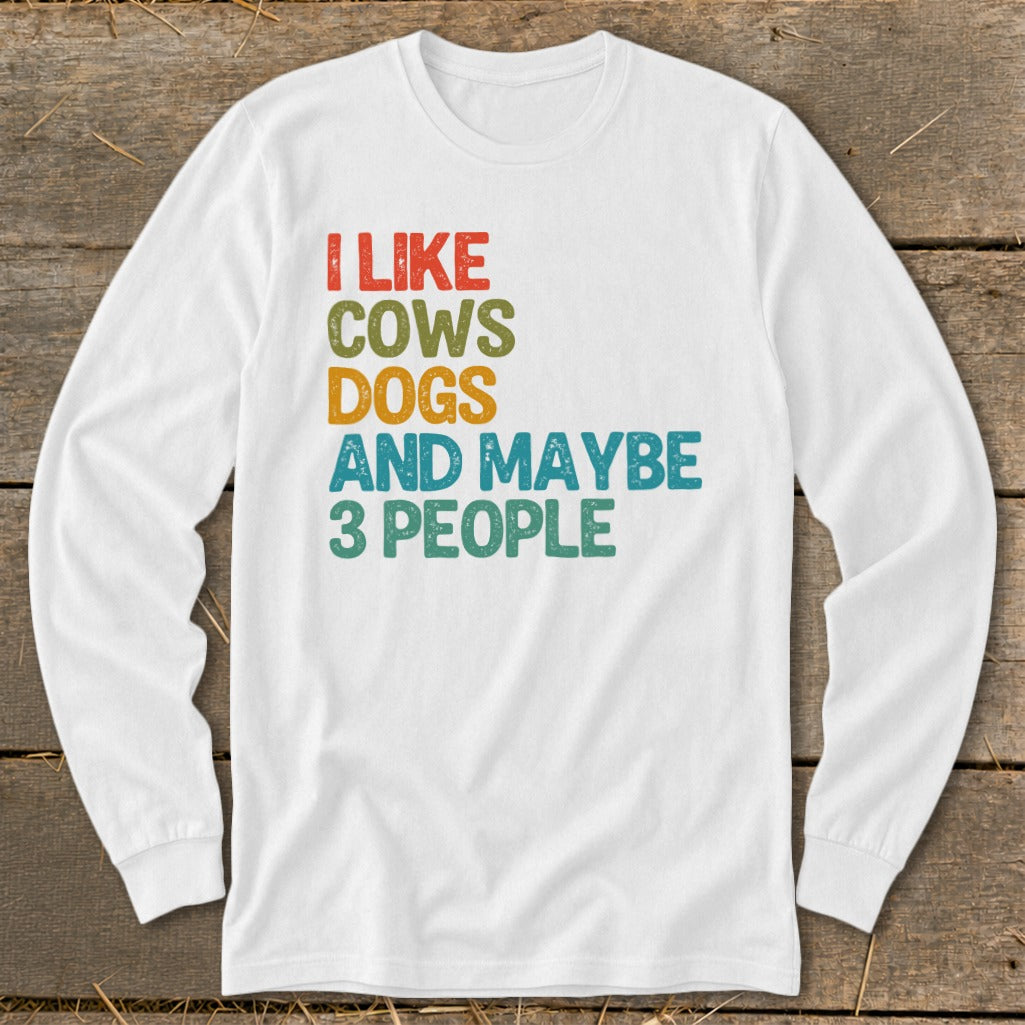 White long-sleeve shirt with text "I LIKE COWS DOGS AND MAYBE 3 PEOPLE."