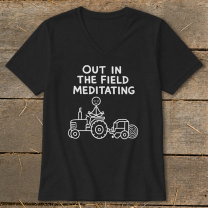 Black t-shirt with "Out in the Field Meditating" text and stick figure on tractor.