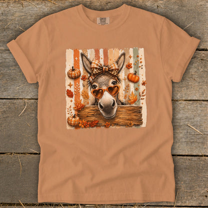 Donkey wearing heart sunglasses and bow on striped autumn background.