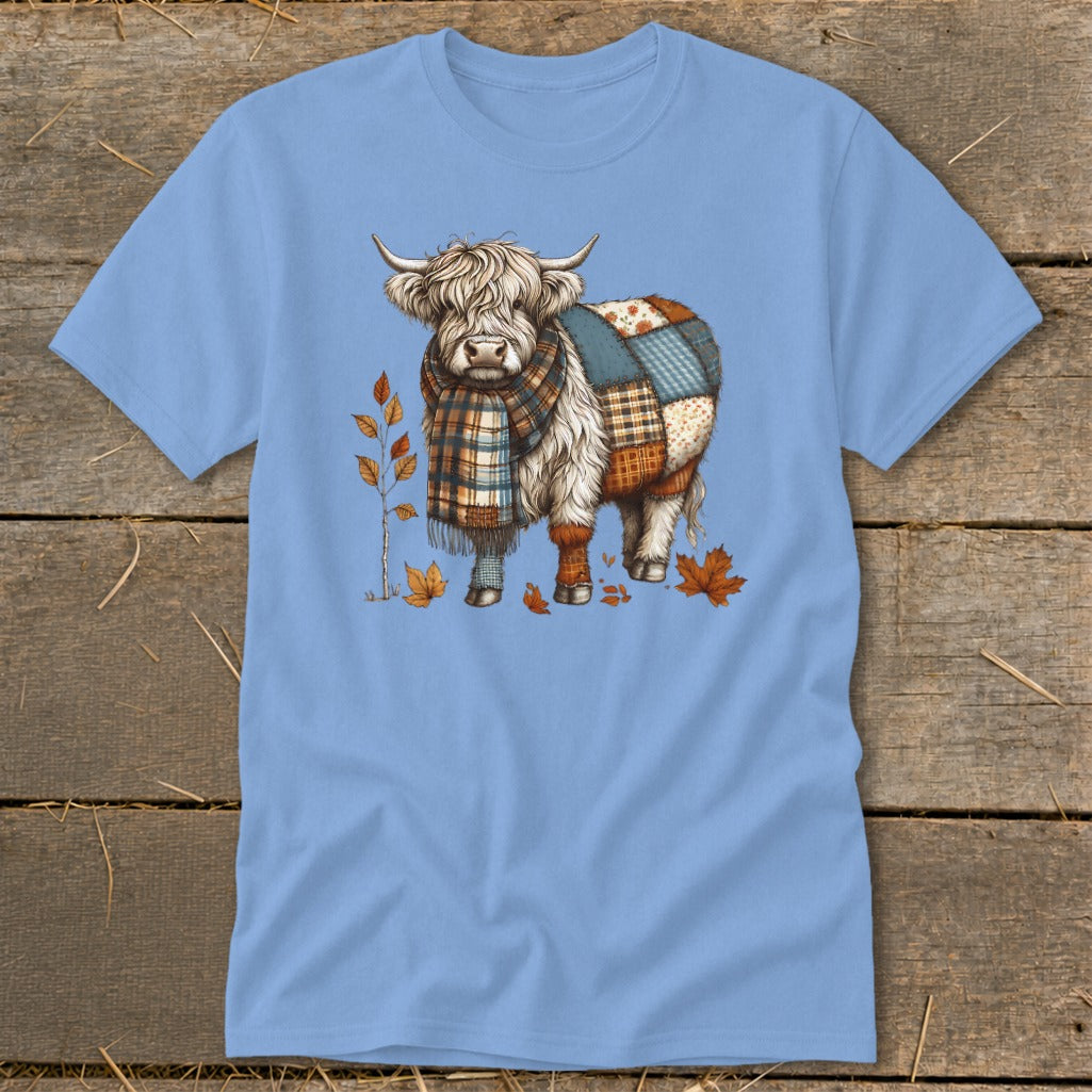 Highland cow with patchwork body and plaid scarf surrounded by autumn leaves.